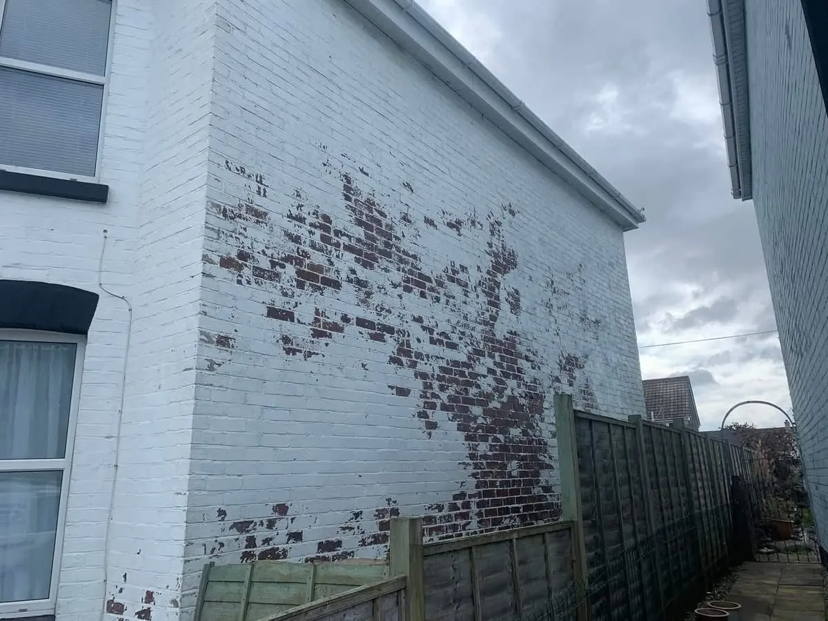 Peeling paint on a brick wall before redecoration in Truro